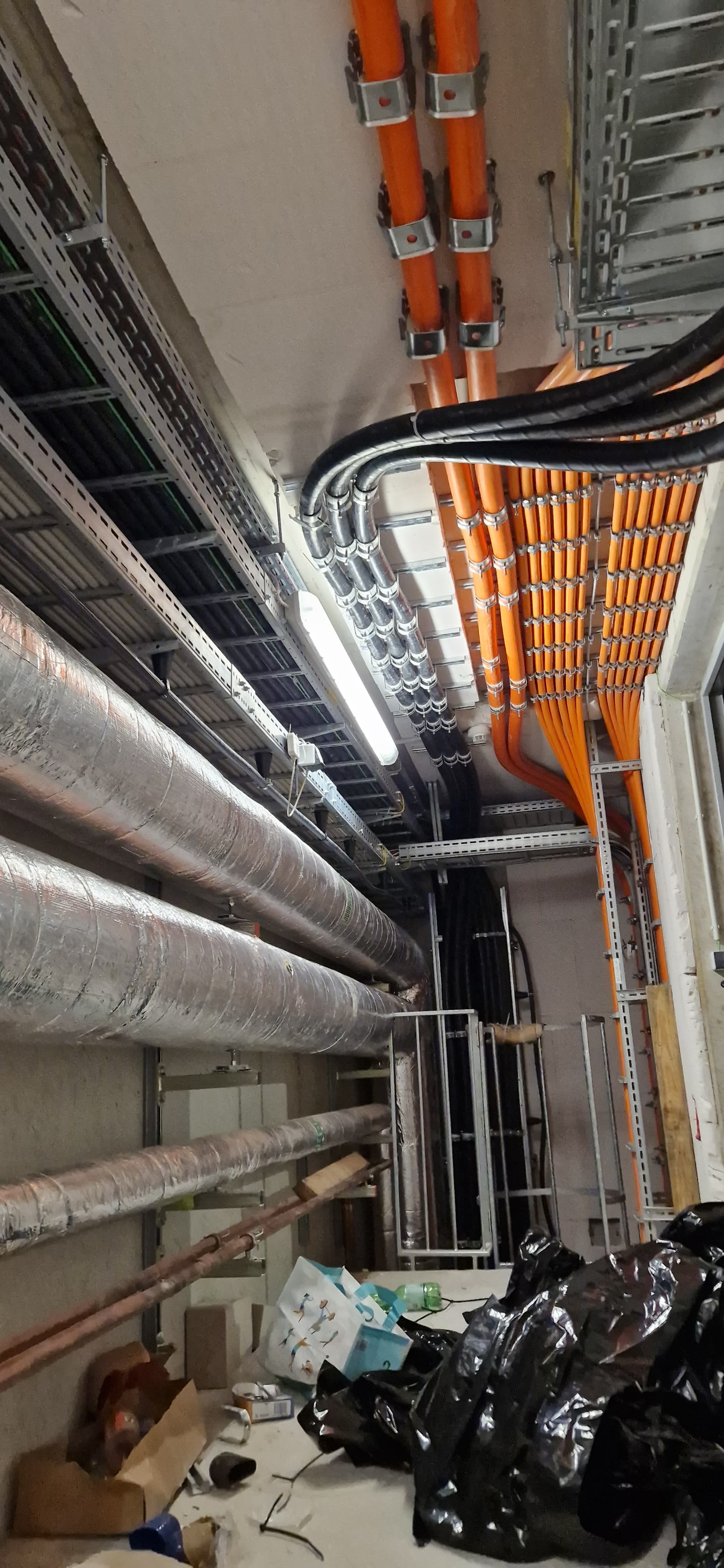 Techniker montieren Kabeltrassen und Leitungen im Technikraum