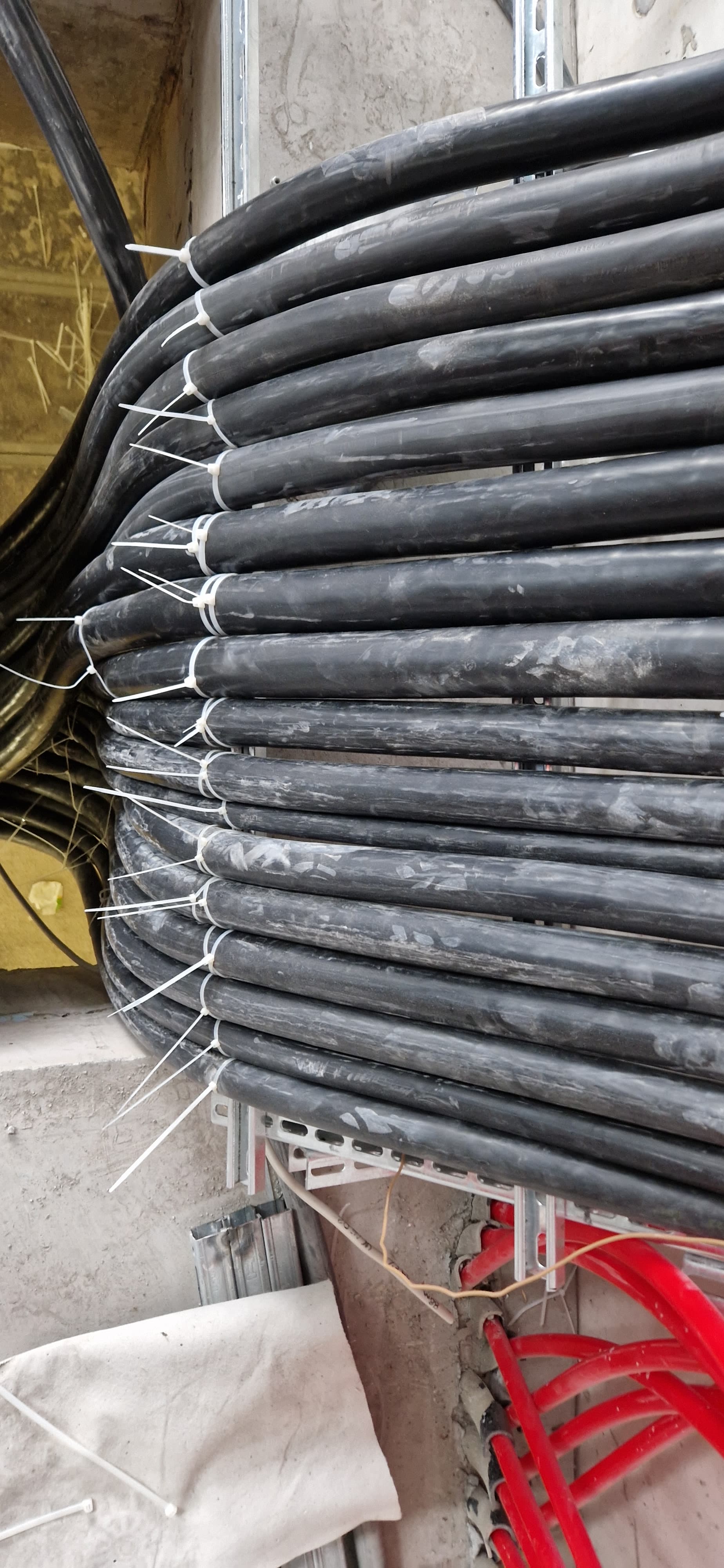 Industriekabel werden in eine Kabeltrasse unter einer Stahlkonstruktion verlegt