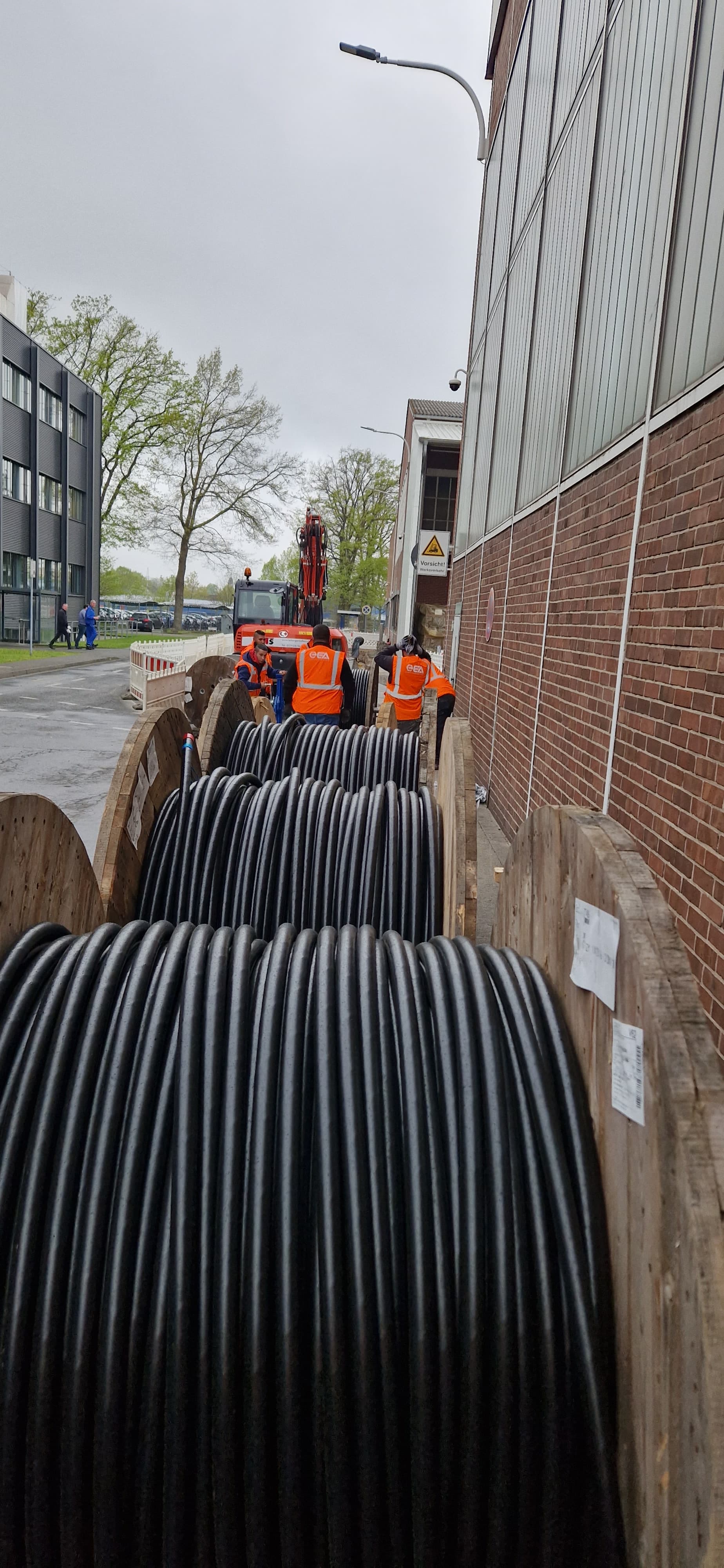 Mehrere Starkstromkabel werden durch eine Wand in eine Elektroverteilung geführt
